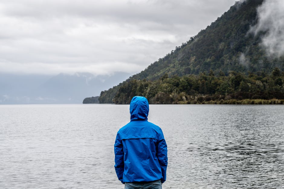 person looking out on water and mountain