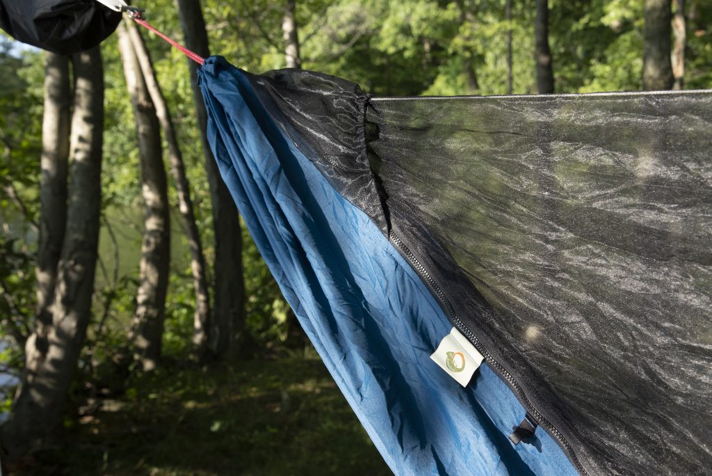 a lightweight camping hammock hung by a lake