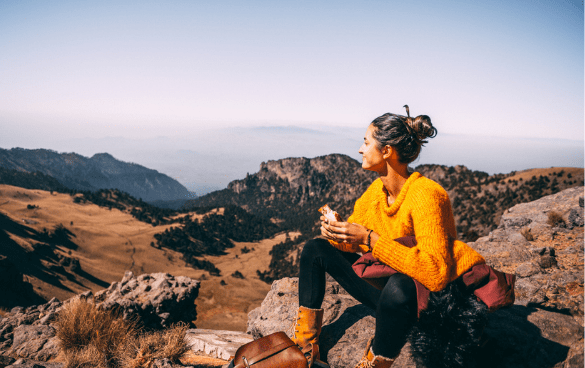 woman eating while on a hike